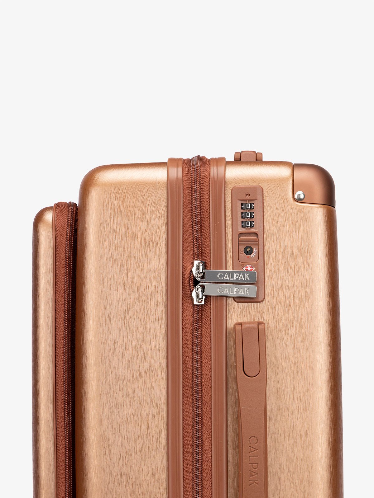 Close up shot of built-in TSA lock on copper CALPAK Front Pocket Ambeur hardside carry-on luggage