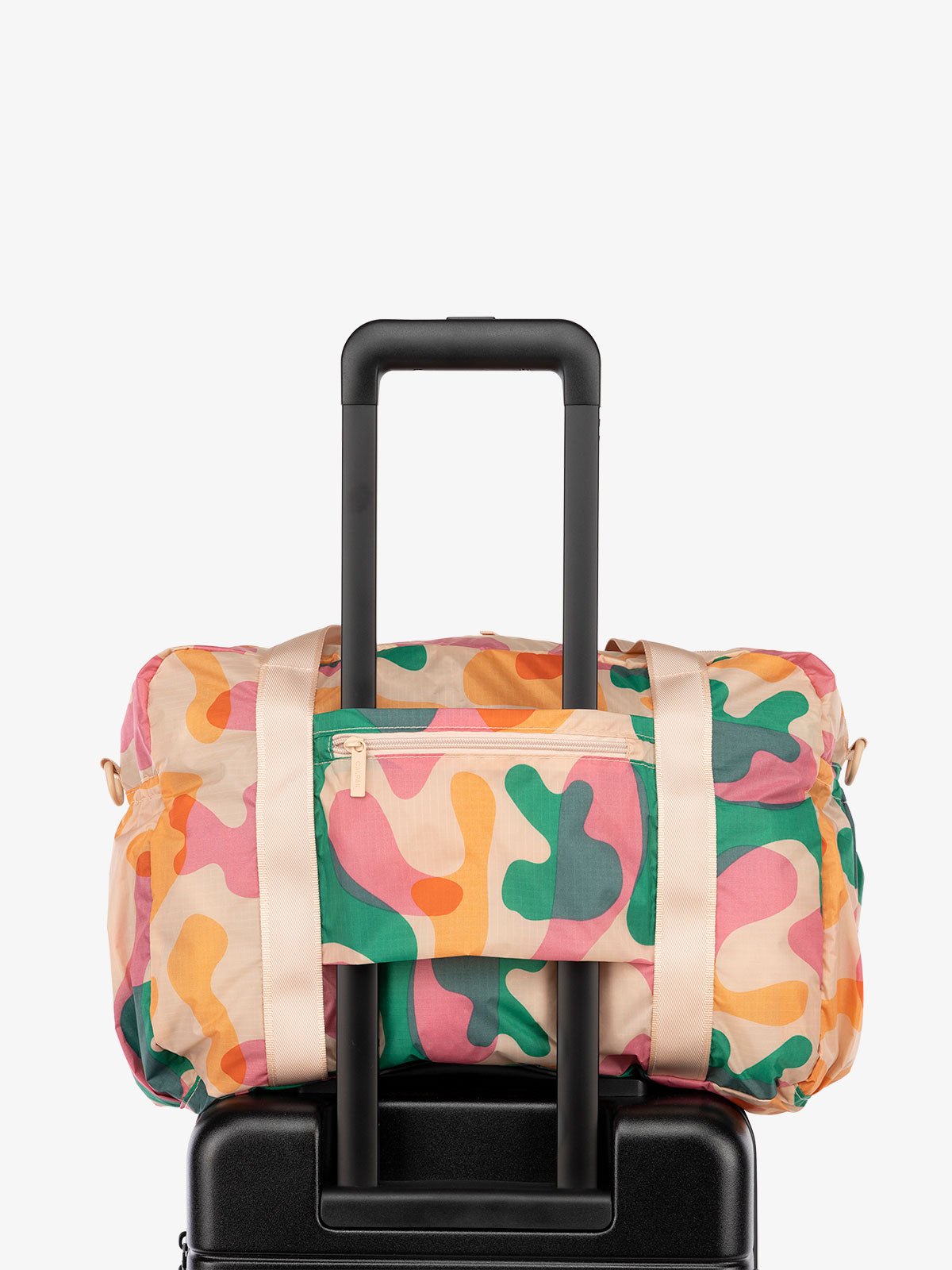 CALPAK Compakt nylon duffle bag with trolley sleeve in pink and green abstract print