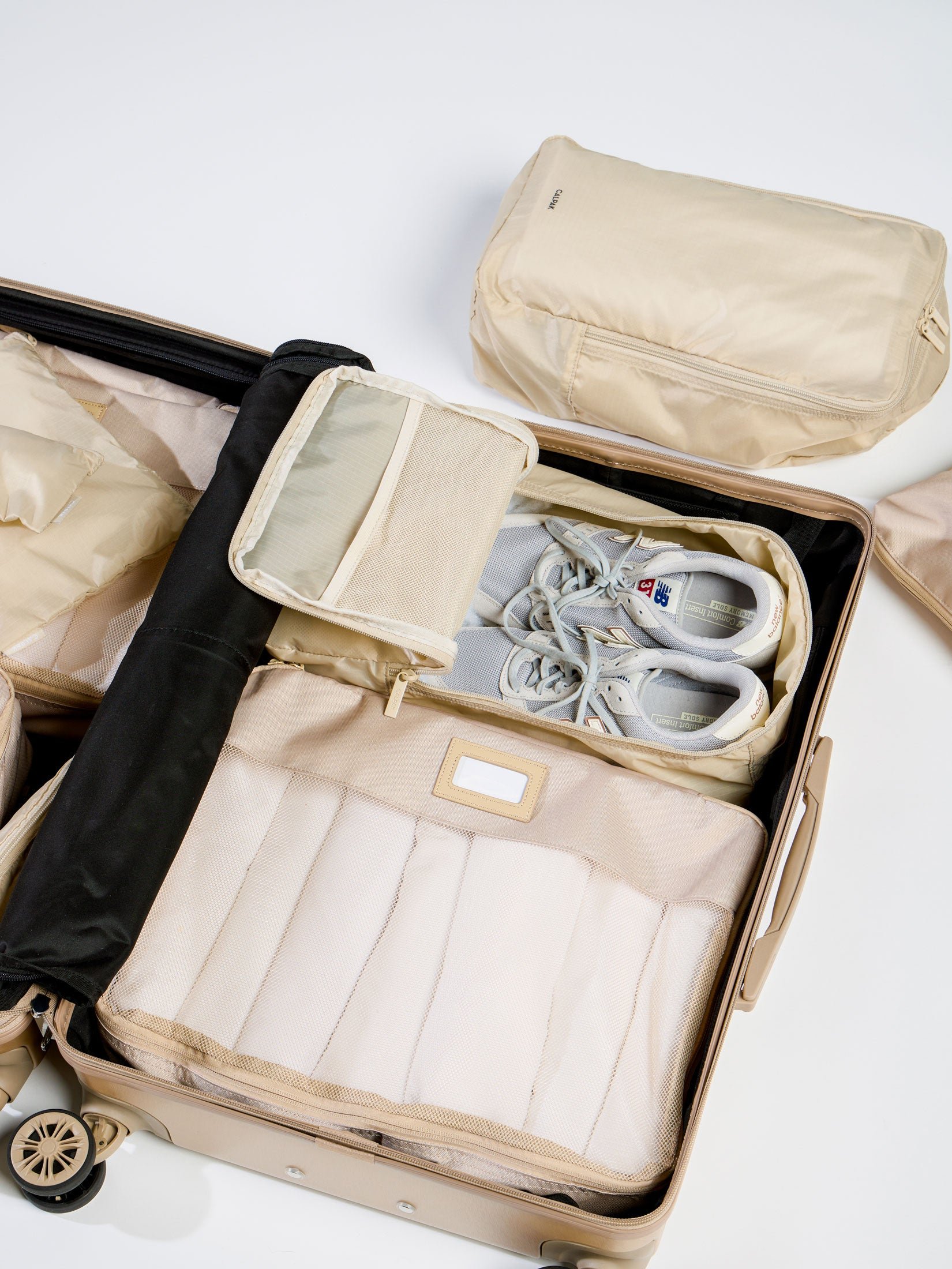 Beige CALPAK Compakt Shoe Bag within carry-on luggage