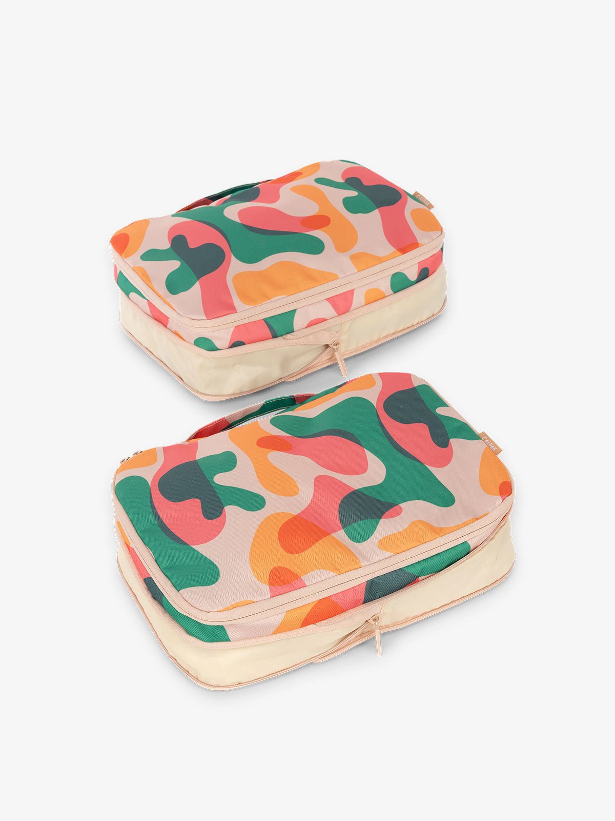 CALPAK compression packing cubes with handles in pink and green abstract print