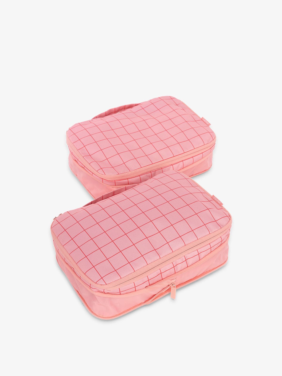 CALPAK compression packing cubes with handles in pink grid print