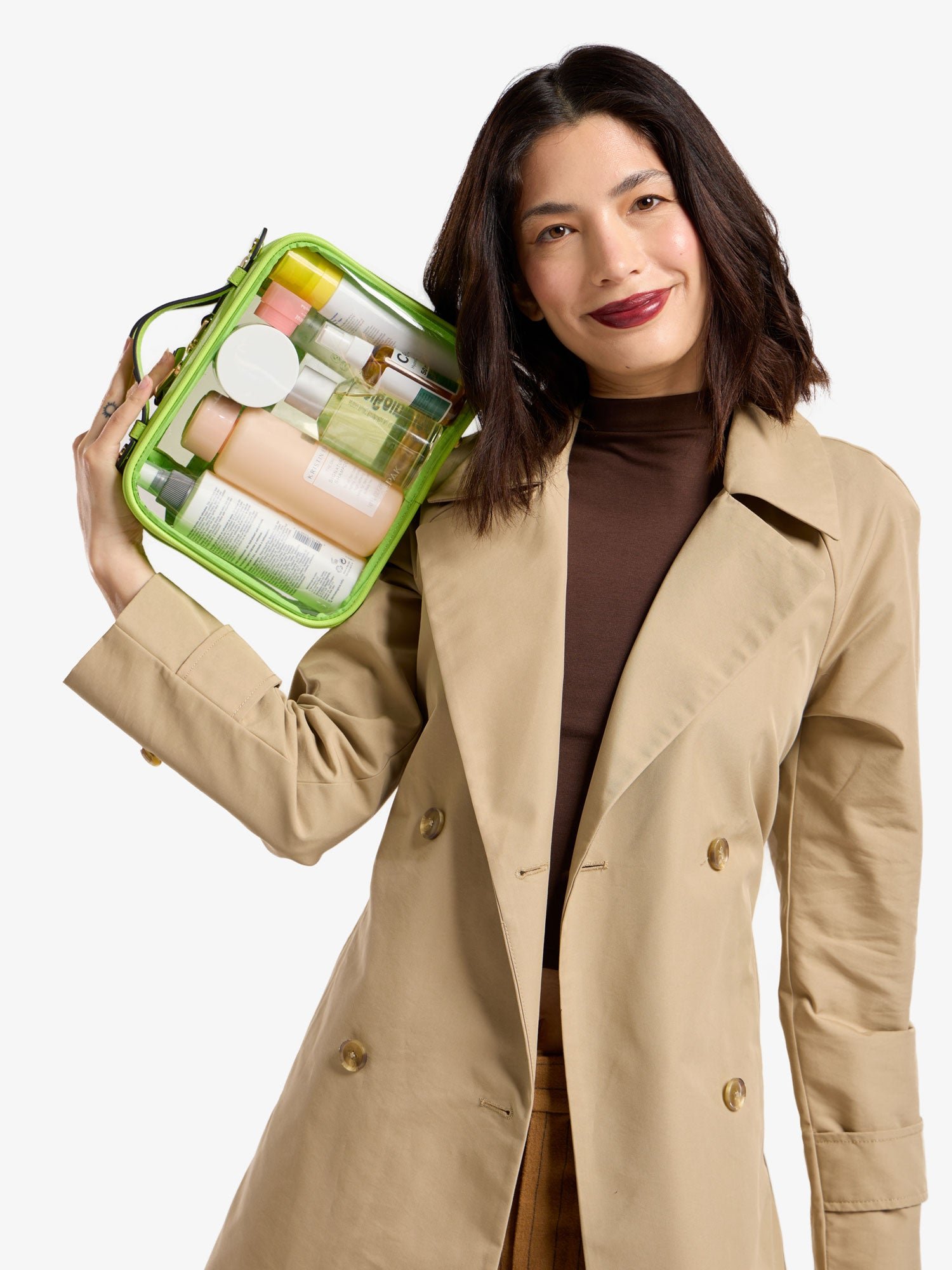 Model holding CALPAK medium clear cosmetic case in electric lime green
