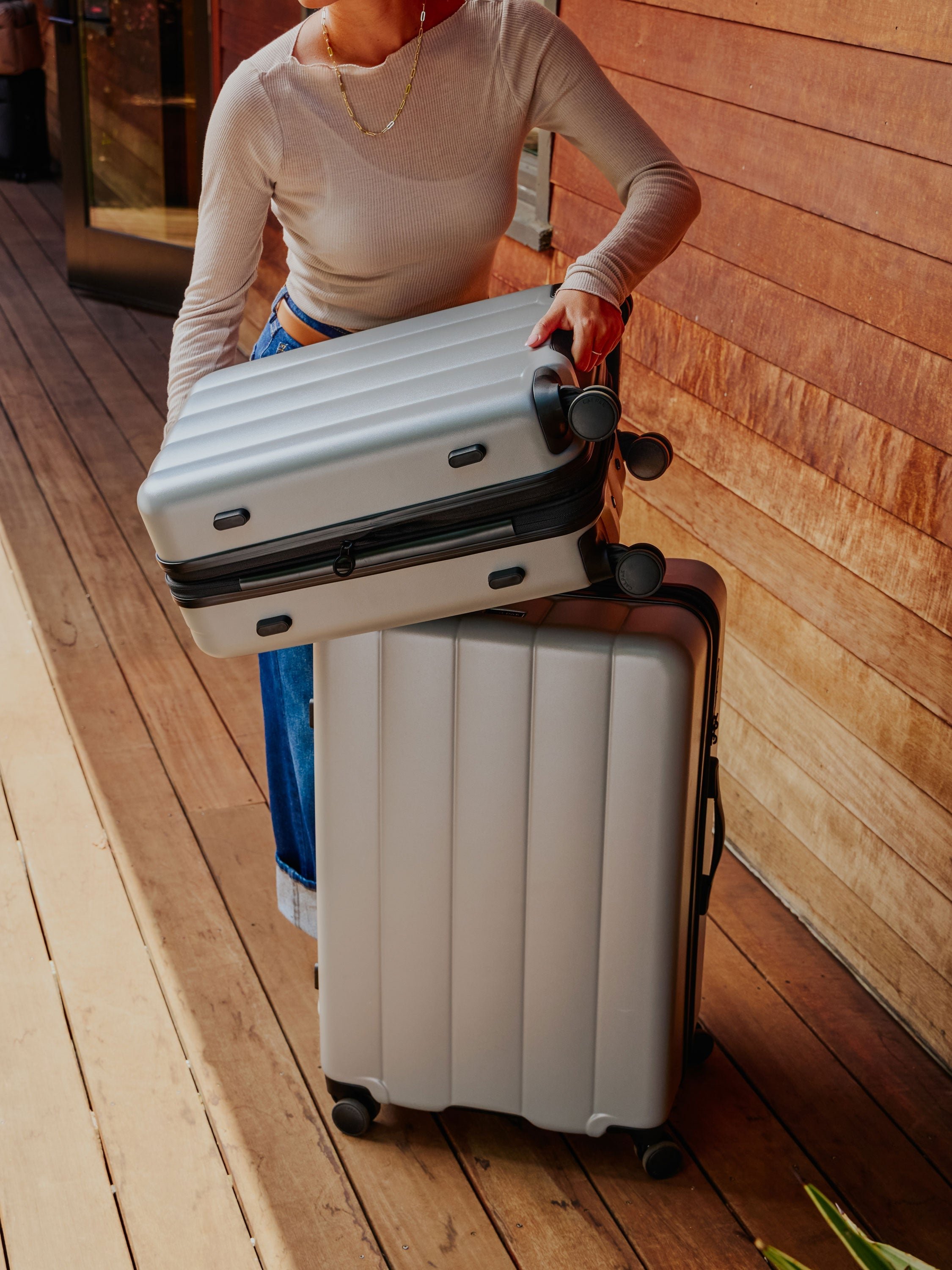 Model displaying the Evry carry-on luggage and large luggage in gray smoke