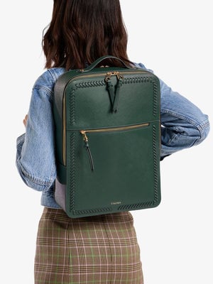 Model wearing dark green CALPAK Kaya 17 inch Laptop Backpack; BPY2301-SQ-EMERALD