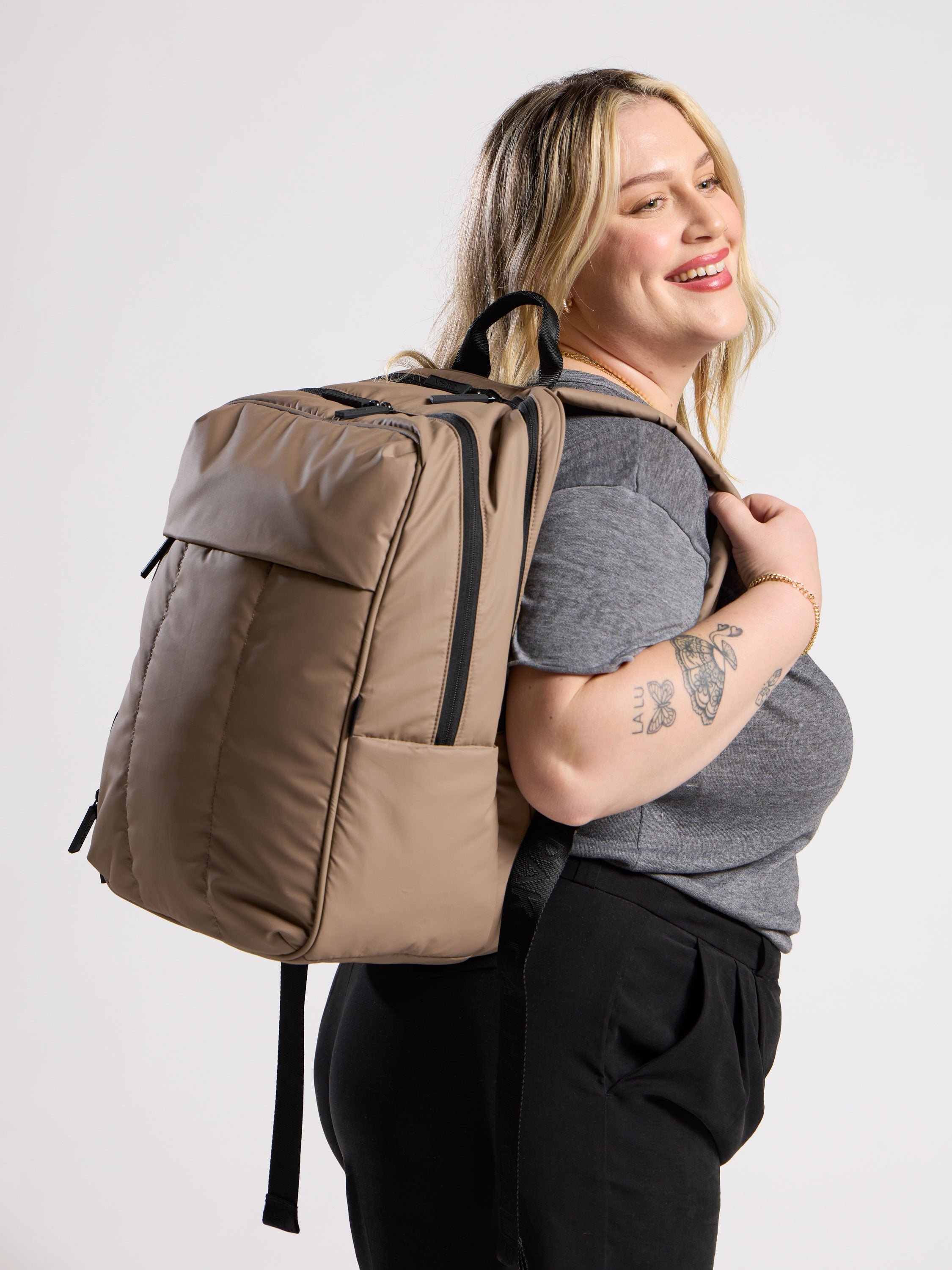 Model wearing luka laptop backpack for 17 inch laptop on back in brown