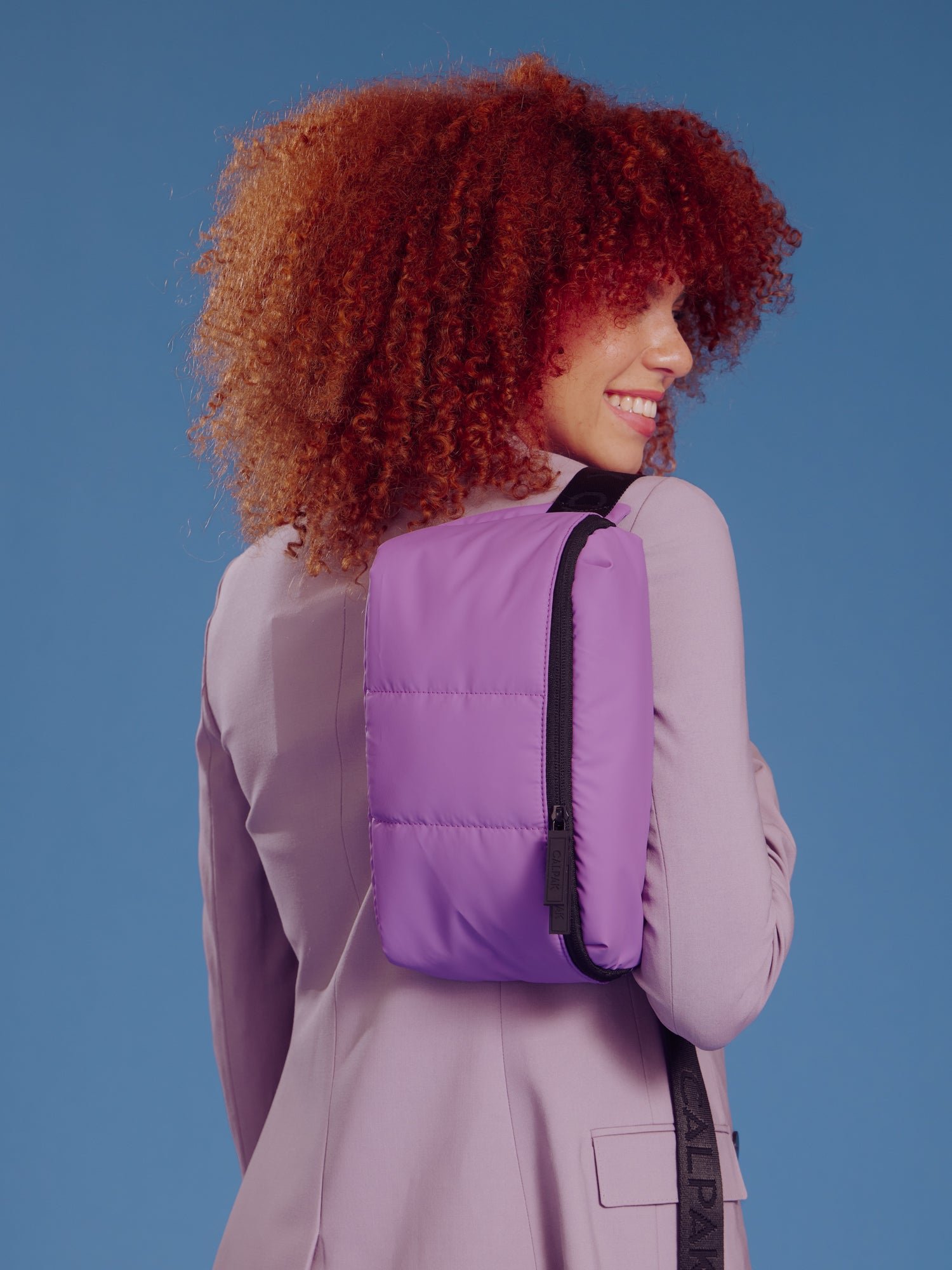 Model wearing CALPAK Luka Belt Bag over shoulder in lilac