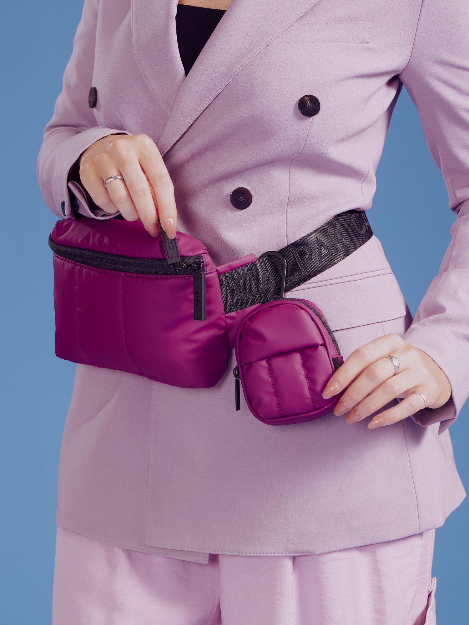 Model wearing CALPAK Luka Mini Belt Bag with Luka Key Pouch clipped to strap in plum