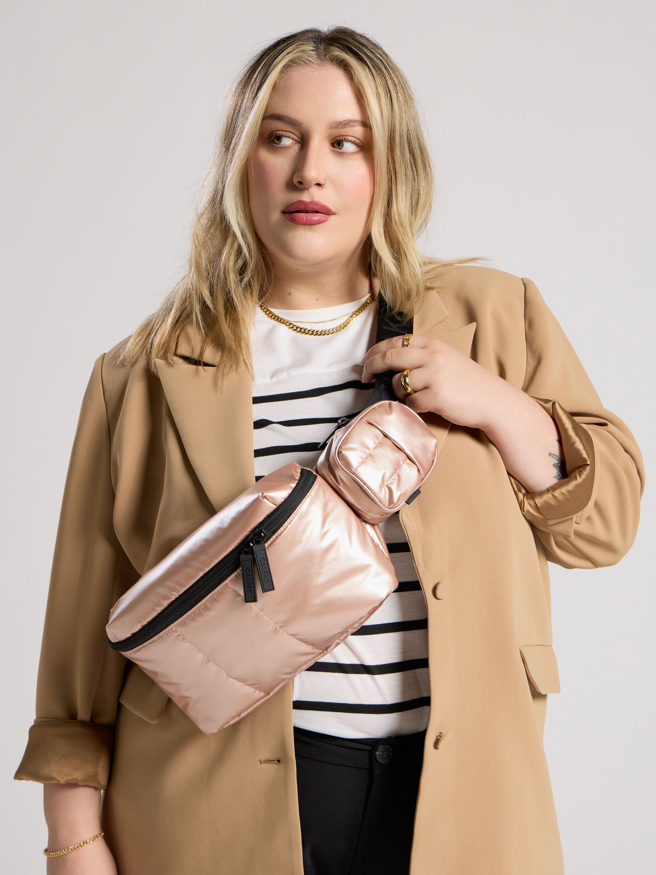 Model wearing Luka Belt Bag as crossbody bag with Luka Key Pouch attached by strap in rose gold