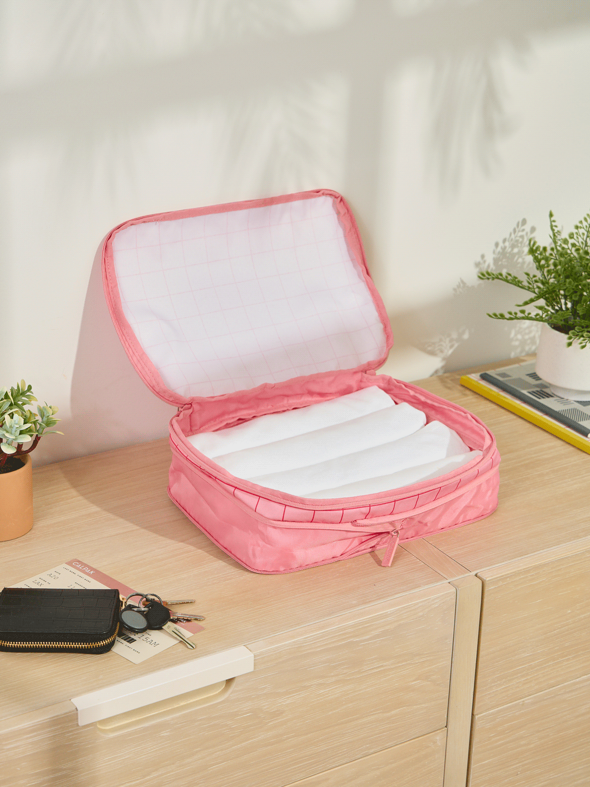 CALPAK Medium Compression Packing Cubes made of durable material and expandable by 4.5" in pink grid