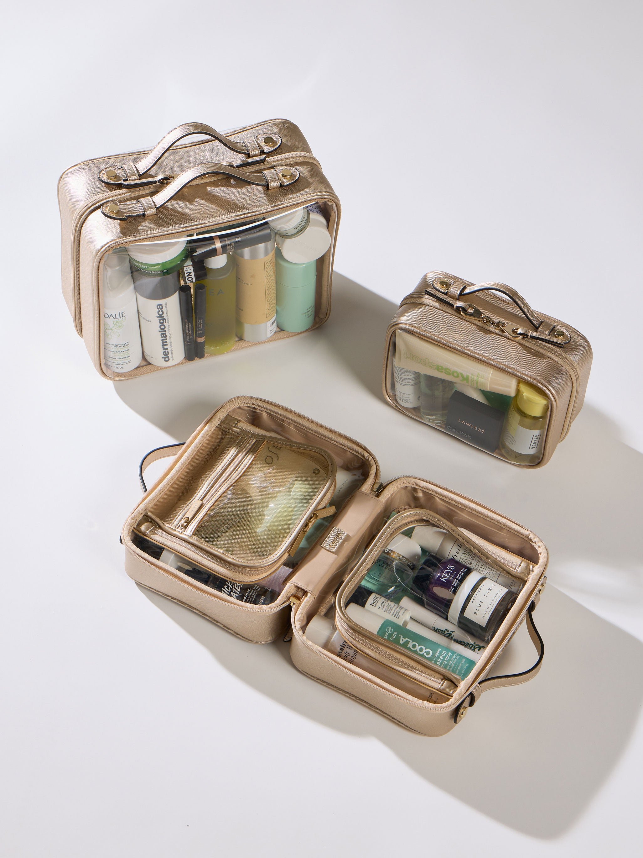 Gold CALPAK Small Clear Cosmetic Case, Medium Cosmetic Case, and Large Clear Cosmetic Case
