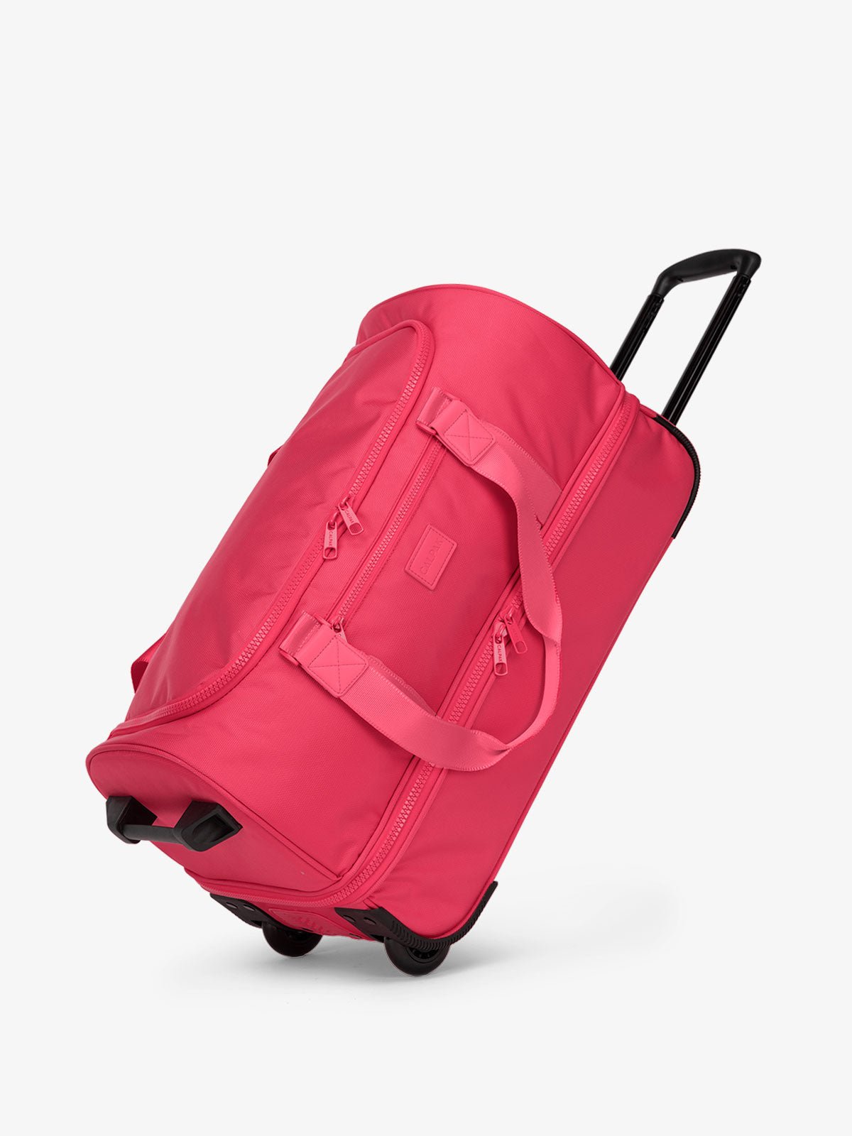 CALPAK Stevyn Rolling Duffel side view with top handle extended in hot pink dragonfruit