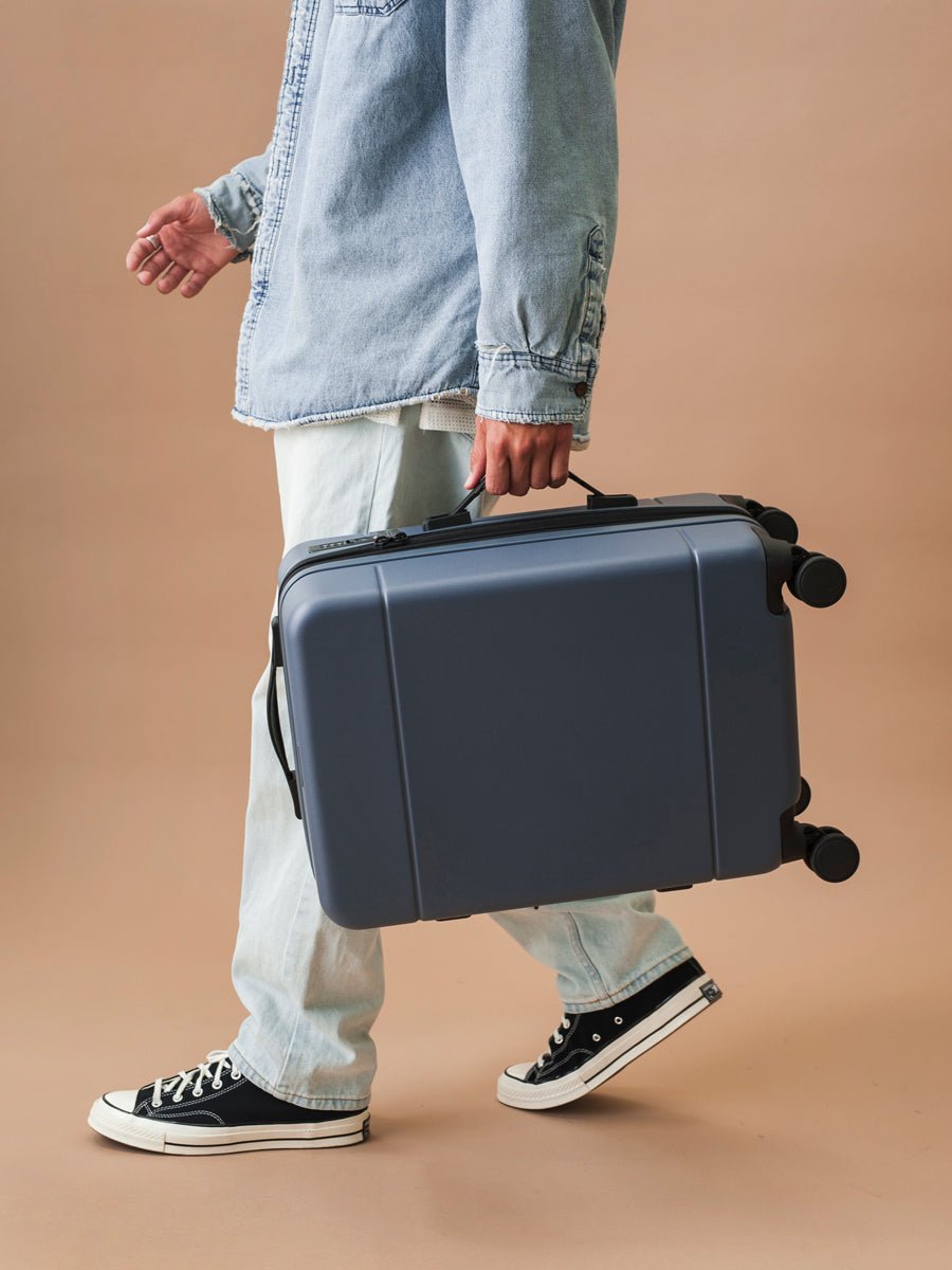 CALPAK Hue rolling carry-on suitcase in blue atlantic color