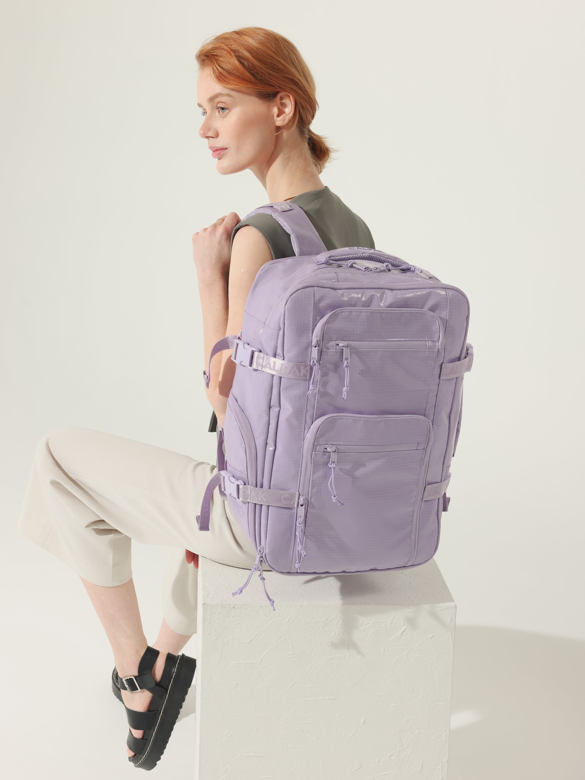 Model wearing CALPAK Terra 26L Laptop Backpack Duffel with adjustable padded shoulder straps in amethyst