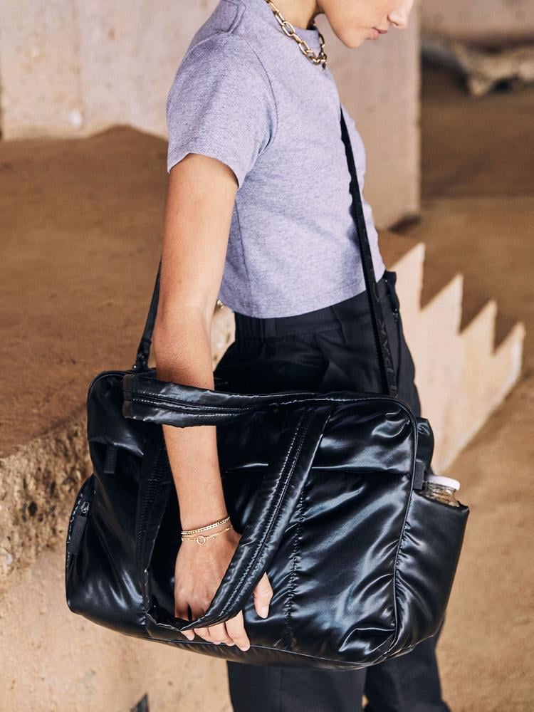 woman with a black CALPAK Luka duffel bag