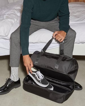 shoe compartment in black CALPAK Stevyn duffel bag; DST7019-MOSS, DST7019-PALM-LEAF, DST7019-BLACK, DST7019-SLATE