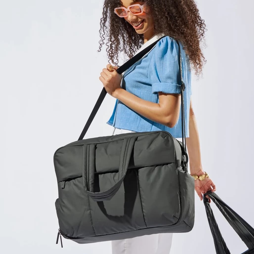 Woman with the CALPAK Luka Large Duffel in Matte Black