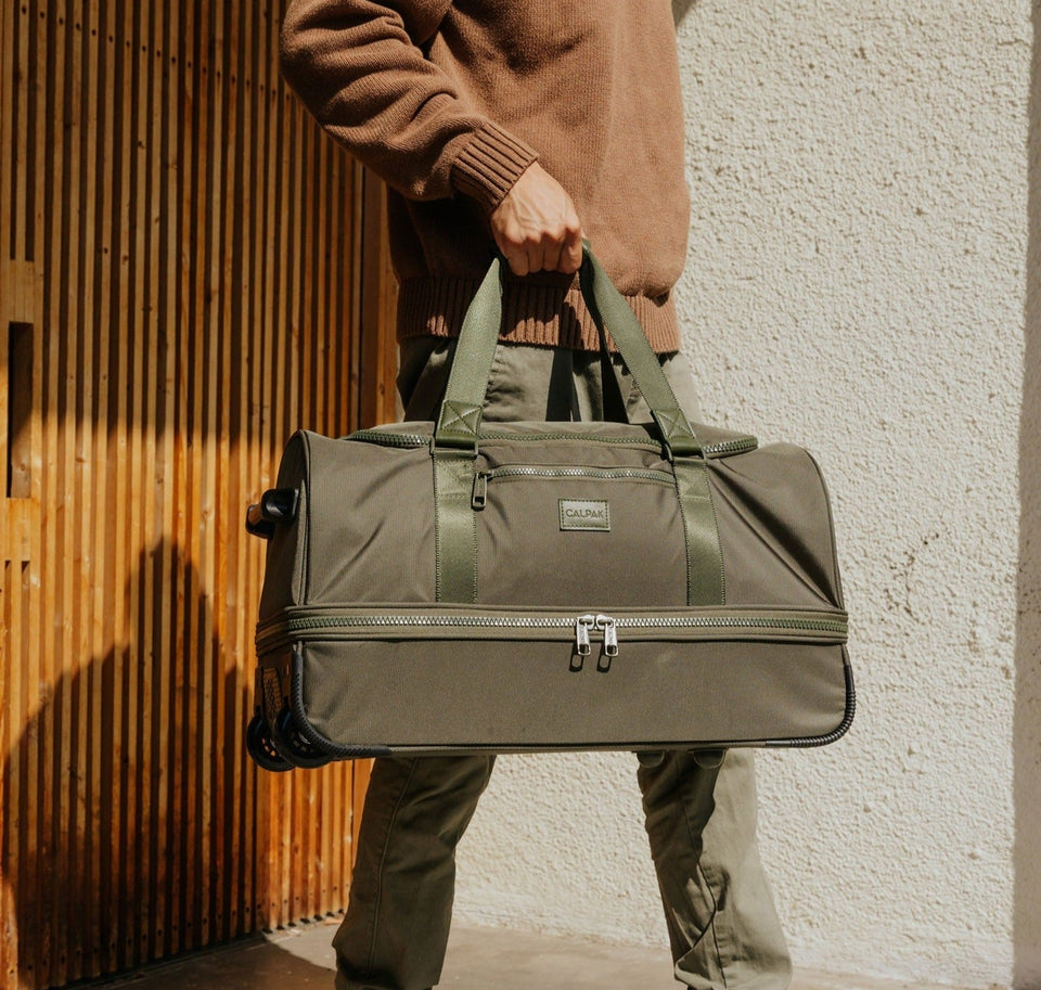 Person holding a green Stevyn Duffel Bag in green