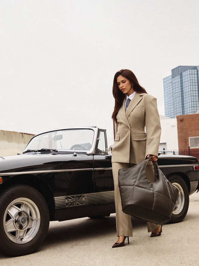 Woman by car holding the CALPAK Luka Everything Tote in Vegan Leather
