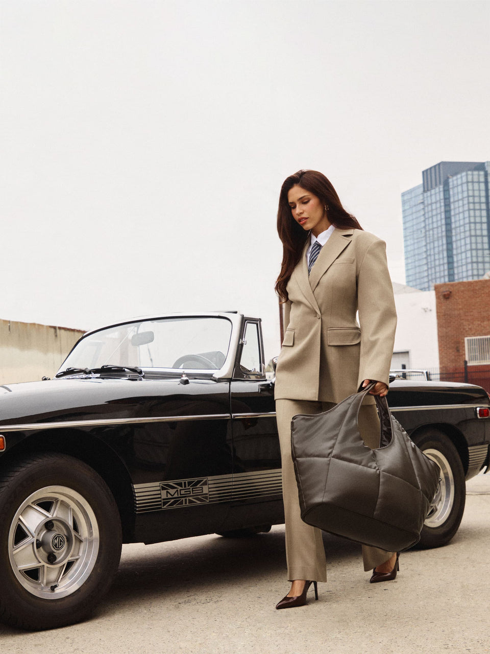 Woman by car holding the CALPAK Luka Everything Tote in Vegan Leather