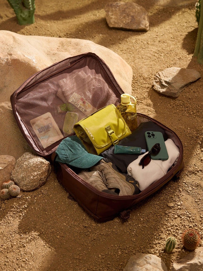 CALPAK Terra Laptop Backpack opened with clothes and Terra Hanging Toiletry Bag