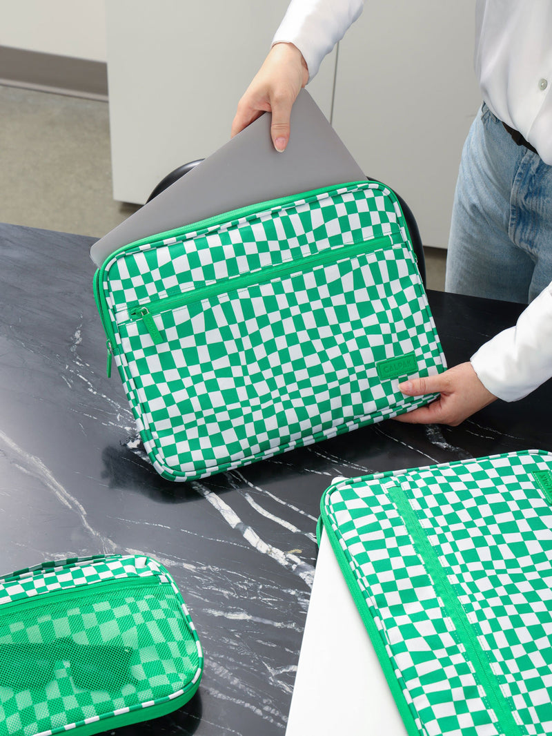 Model putting laptop into 13"-14" Padded Laptop Sleeve in Green Checkerboard from CALPAK