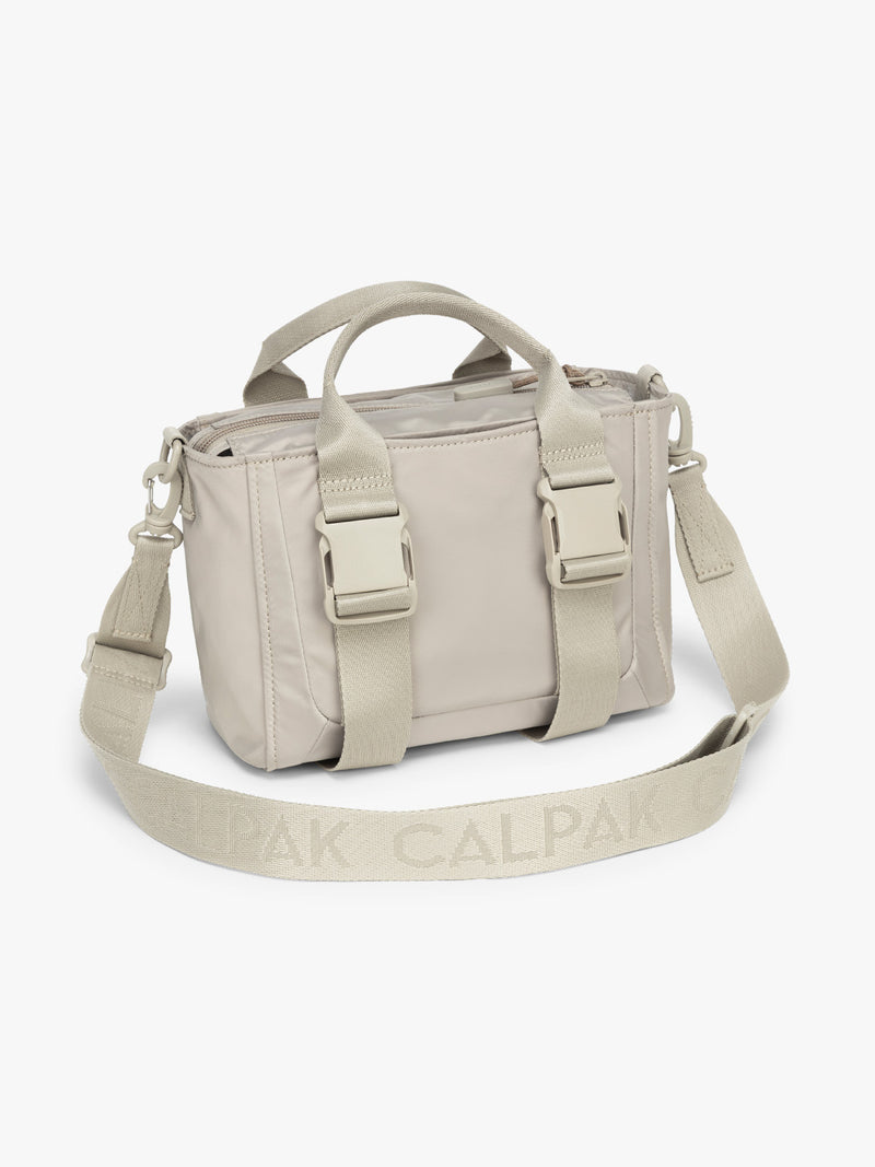 CALPAK Fit Gym Crossbody Bag in beige Greige side view with white background
