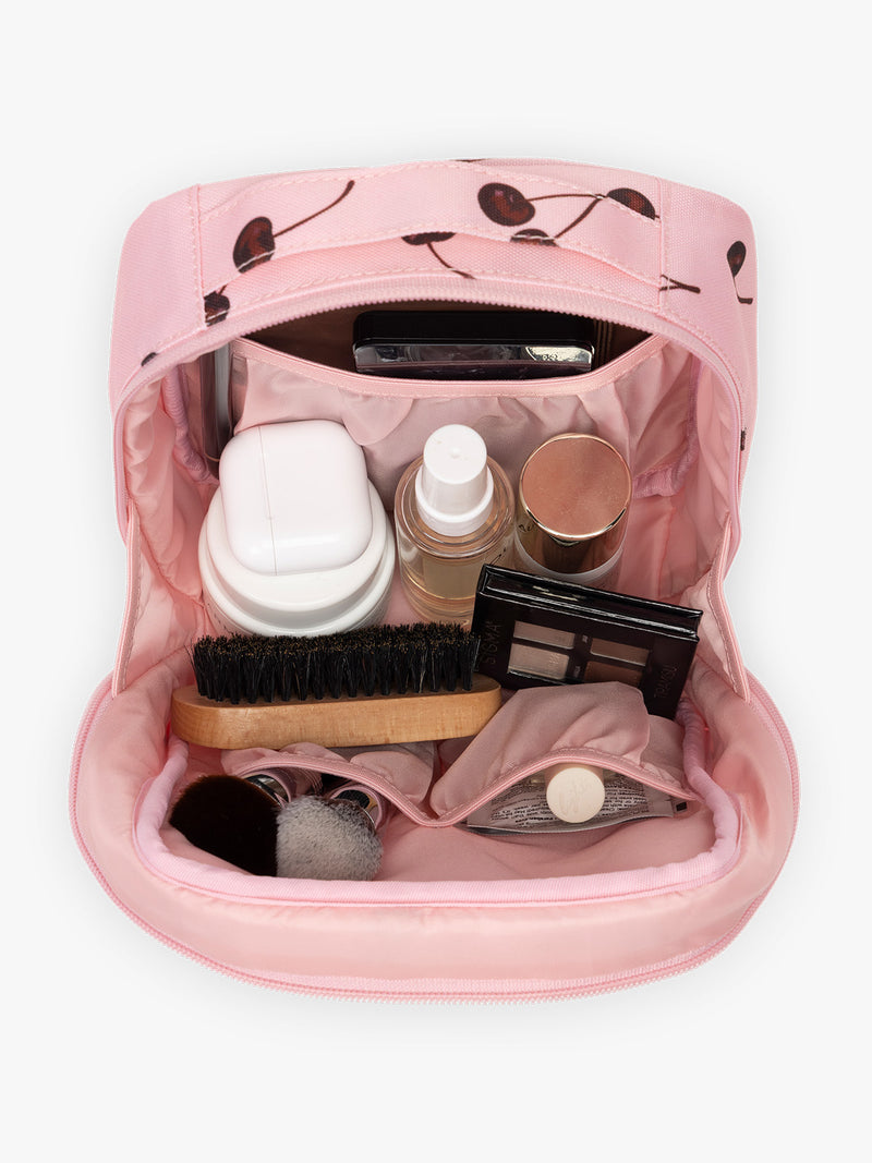 Opened view with items inside of CALPAK Everything Cube pink with cherry print Blossom Pink