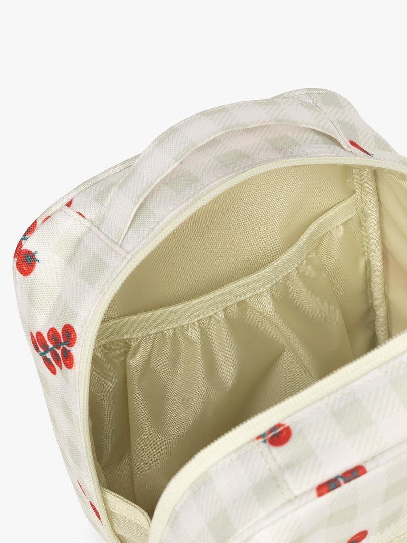 Pockets of CALPAK Everything Cube in light and green gingham pattern with tomato print