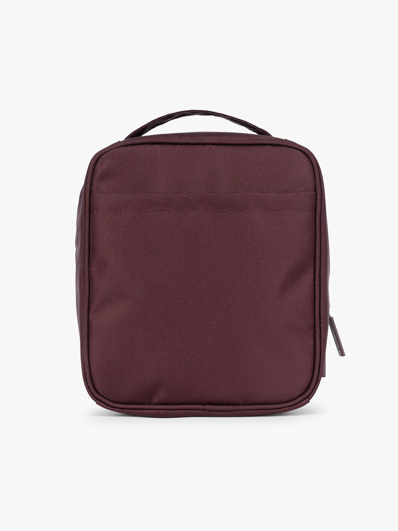 Backside of the dark burgundy Dark Cherry color of the CALPAK Everything Cube organizer with a top handle, a front zippered pocket, and a textured mesh lower panel, shown against a plain white background