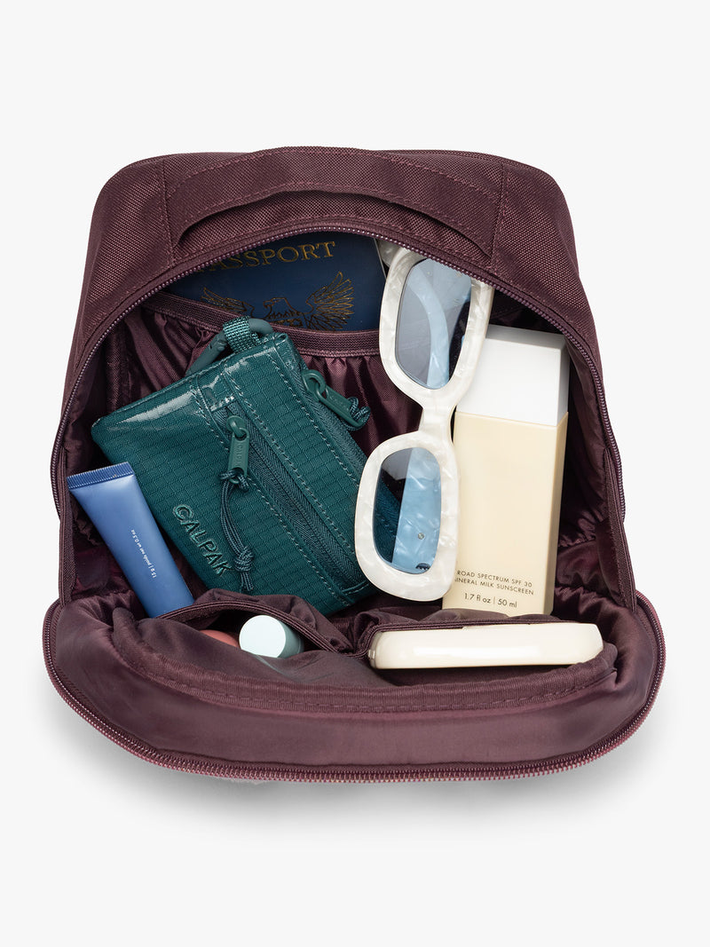 Inside the Dark burgundy Dark Cherry color of the CALPAK Everything Cube organizer with a top handle, a front zippered pocket, and a textured mesh lower panel, shown against a plain white background