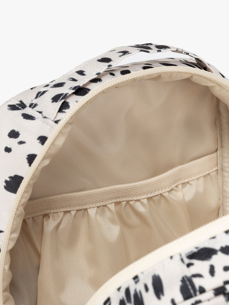 Closer up of compartment of White with black leopard print in Snow Leopard the CALPAK Everything Cube organizer with a top handle, a front zippered pocket, and a textured mesh lower panel, shown against a plain white background