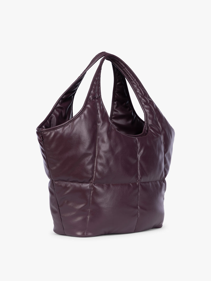 Side view of a Dark Cherry quilted puffer CALPAK Luka Everything Tote Bag with a smooth finish and double shoulder straps, shown against a plain white background