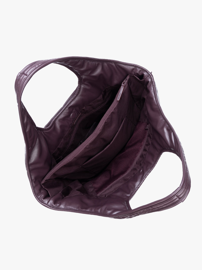Top view of the inside of a Dark Cherry quilted puffer CALPAK Luka Everything Tote Bag with a smooth finish and double shoulder straps, shown against a plain white background