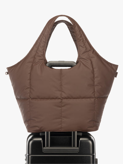 Luggage trolley sleeve of the CALPAK Luka Everything Laptop tote in brown Walnut with shoulder strap on a white background; AET2601-WALNUT view 1