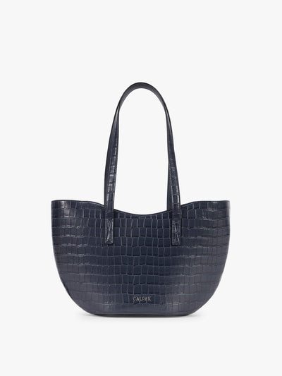 A navy blue crocodile-embossed CALPAK Haven Tulip tote bag with double shoulder straps against a plain white background; AHP2601-NAVY-FAUX-CROC view 1