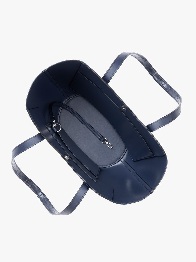 Top down view of a navy blue crocodile-embossed CALPAK Haven Tulip tote bag with double shoulder straps against a plain white background