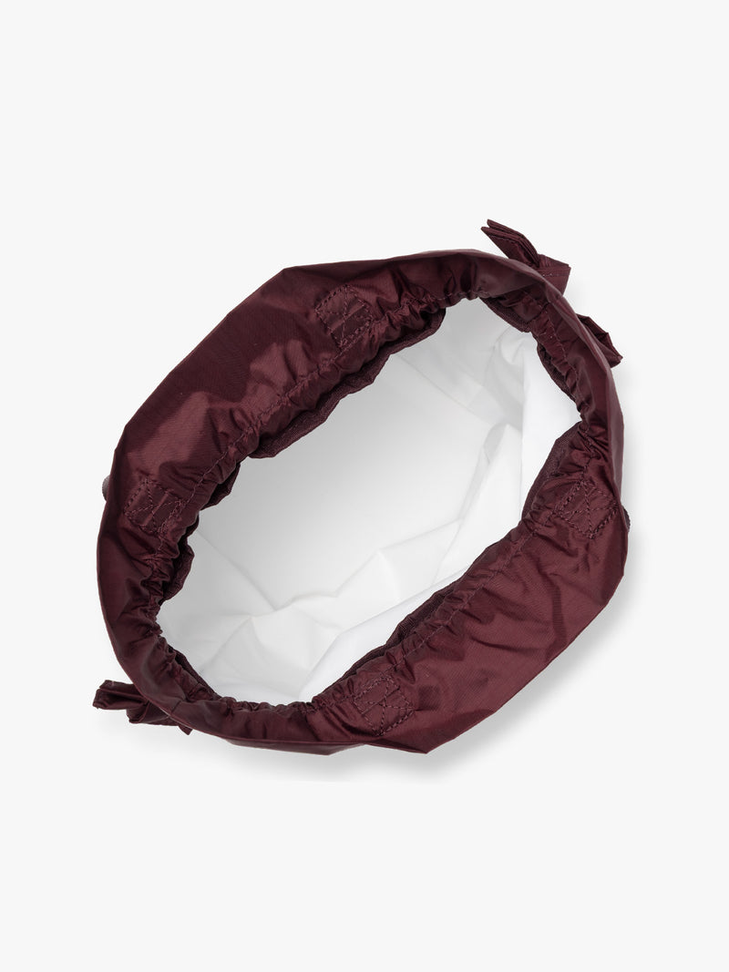 Opened burgundy Dark Cherry CALPAK Insulated Lunch Bag with top handles, featuring a white interior lining shown against a plain white background