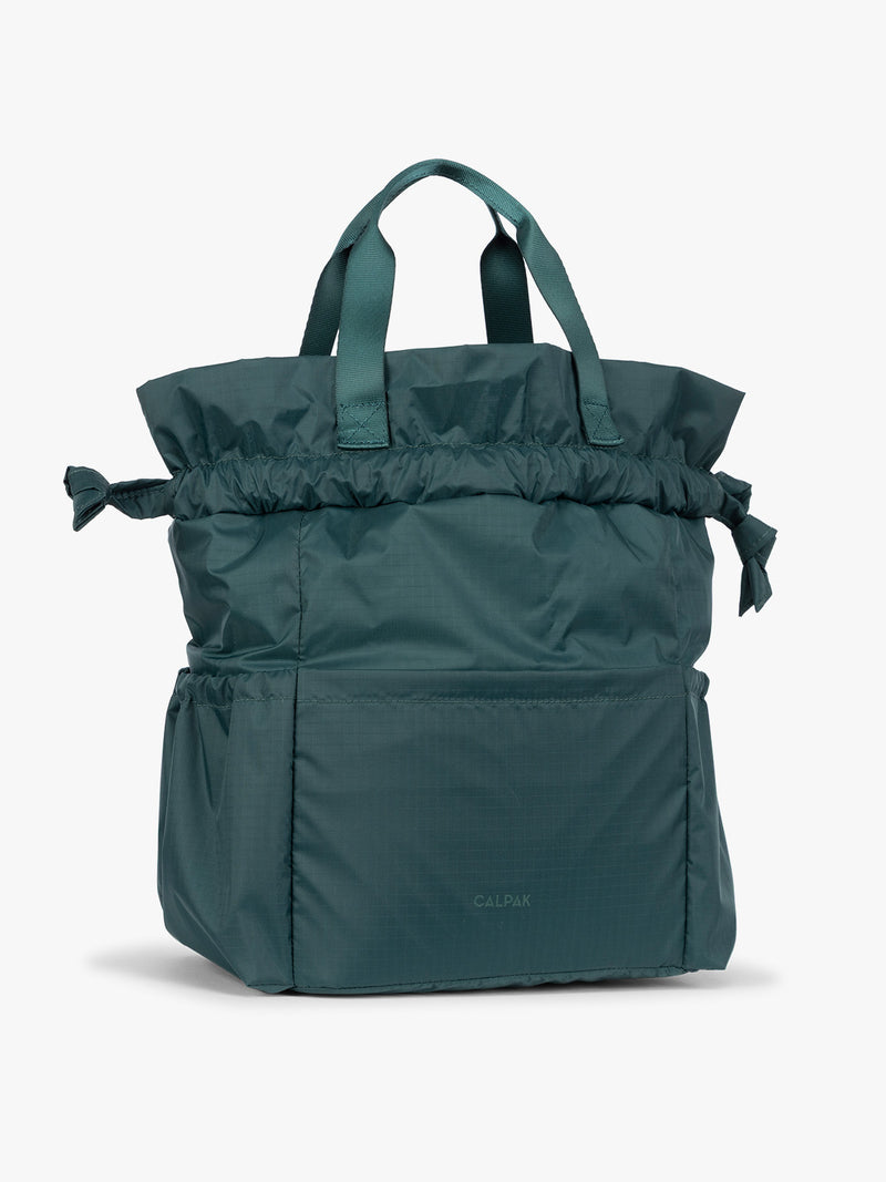 Dark teal green Kale CALPAK Insulated Lunch Bag with top handles, featuring an expandable function shown against a plain white background