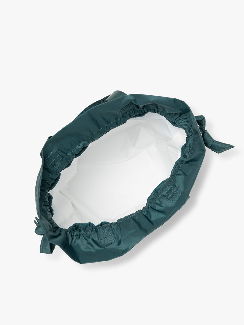 Opened dark teal green Kale CALPAK Insulated Lunch Bag with top handles, featuring a white interior lining shown against a plain white background