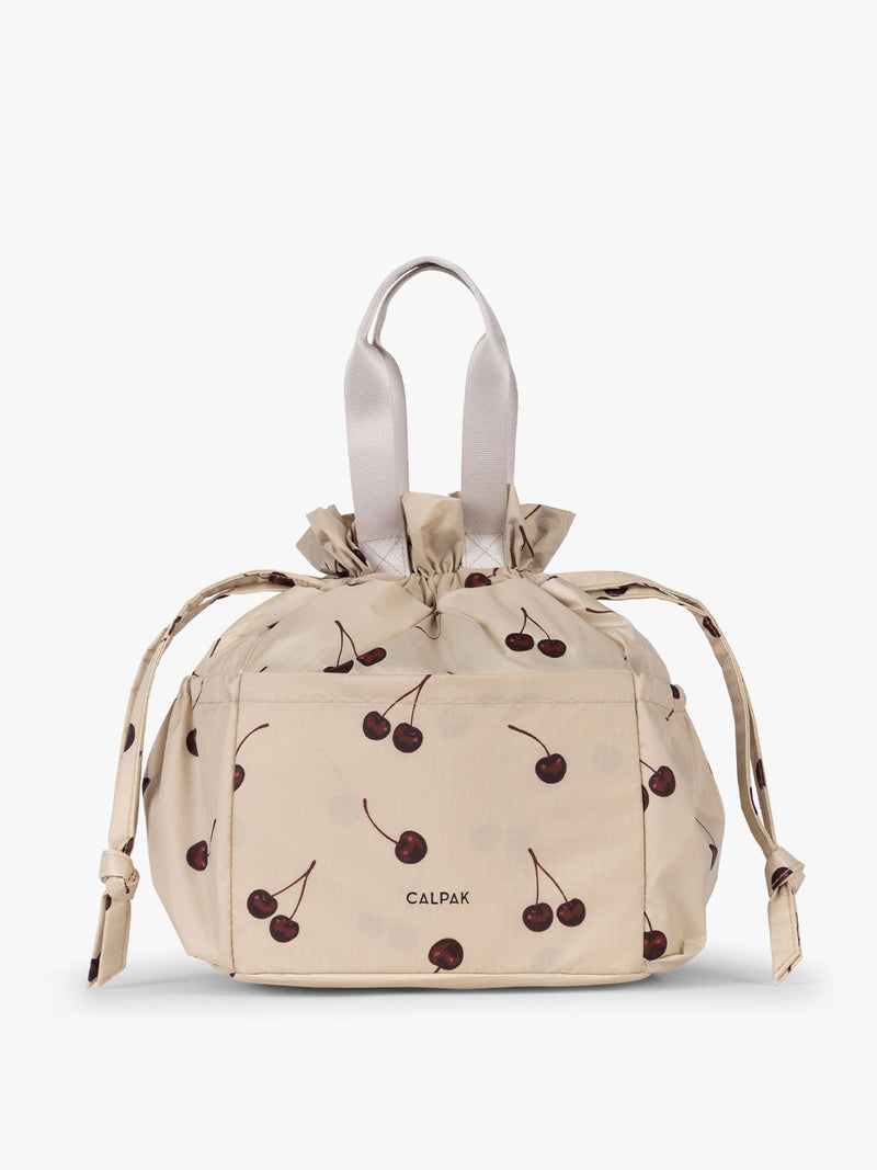 CALPAK Insulated Lunch Bag in Oatmeal Cherry in tan with cherry print with drawstring
