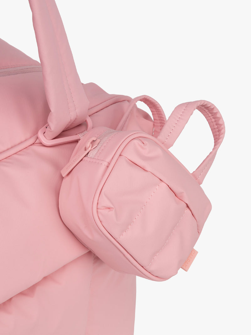 CALPAK Luka Duffel Key Pouch in pink Blossom clipped onto bag