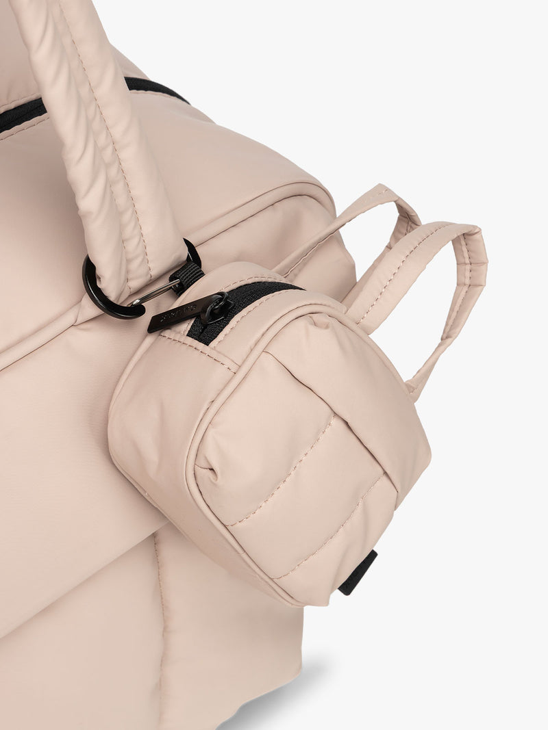 CALPAK Luka Duffel Key Pouch in pink Rose Quartz clipped onto the Luka Duffel in pink Rose Quartz
