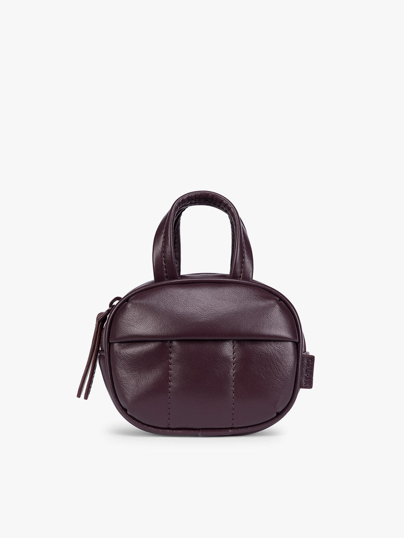 A deep burgundy Dark Cherry vegan leather top-handle CALPAK Luka Zip Bag Charm with a zippered front pocket and a small side strap, shown against a plain white background