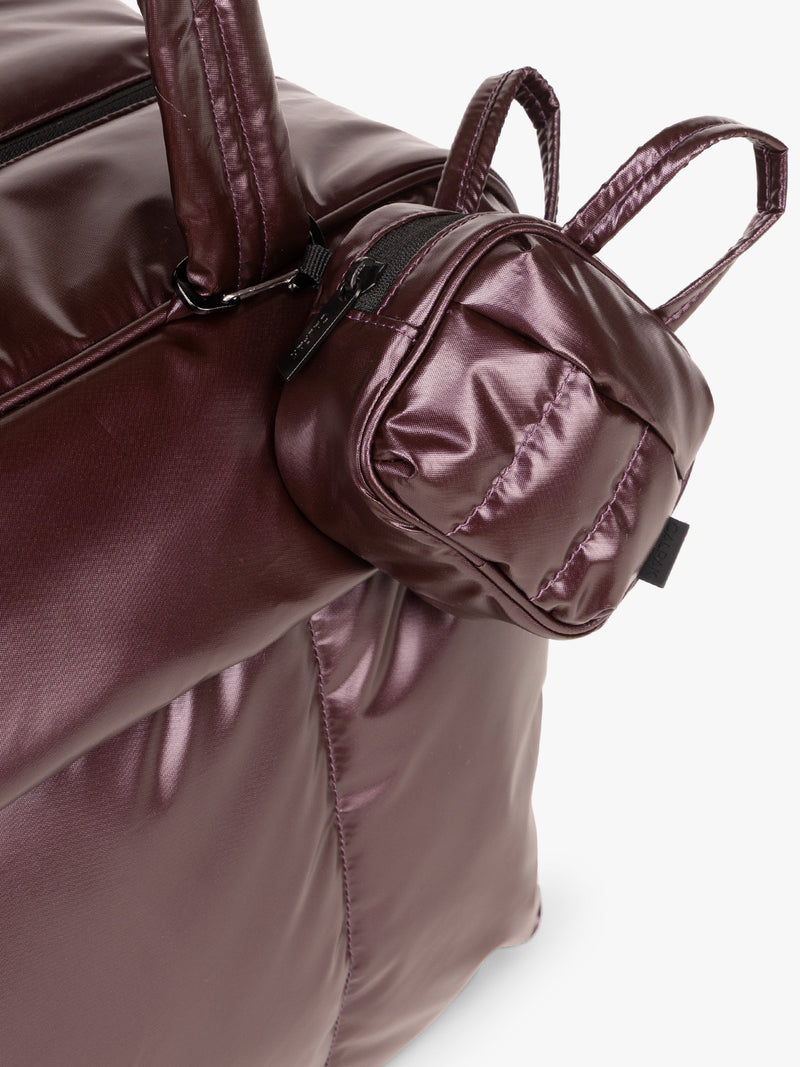 CALPAK Luka Duffel Key Pouch in marron Glazed Dark Cherry clipped on a bag