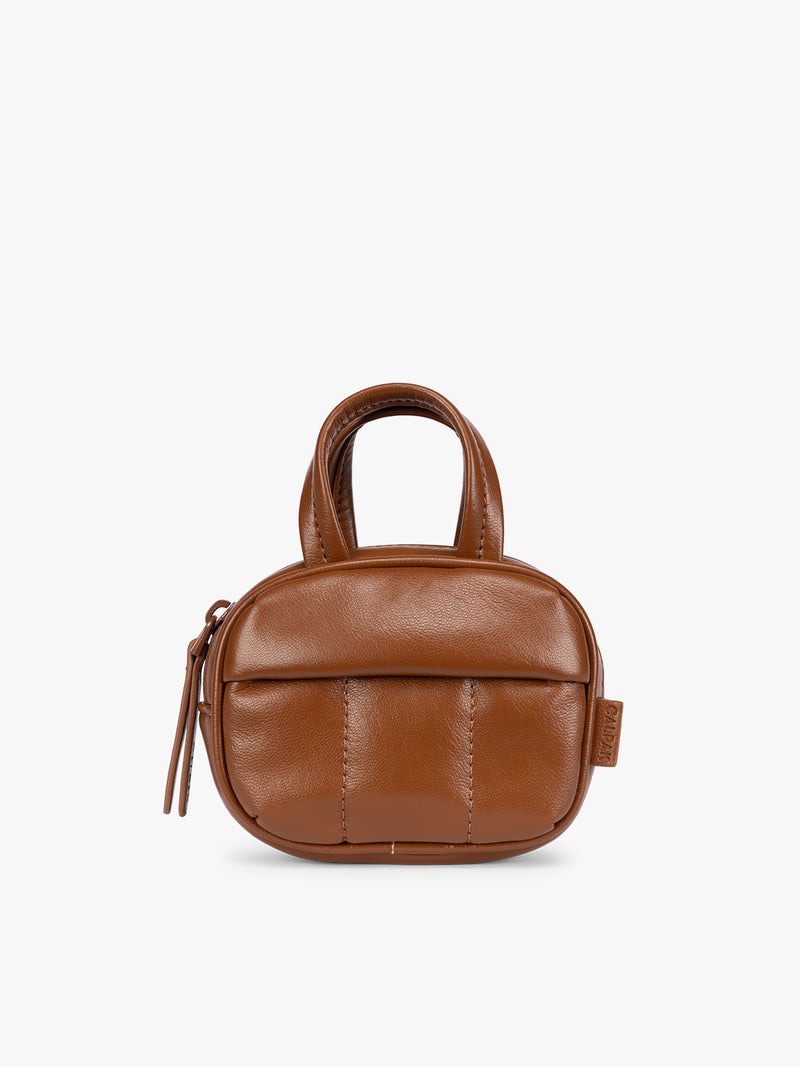 A light Honey Brown vegan leather top-handle CALPAK Luka Zip Bag Charm with a zippered front pocket and a small side strap, shown against a plain white background