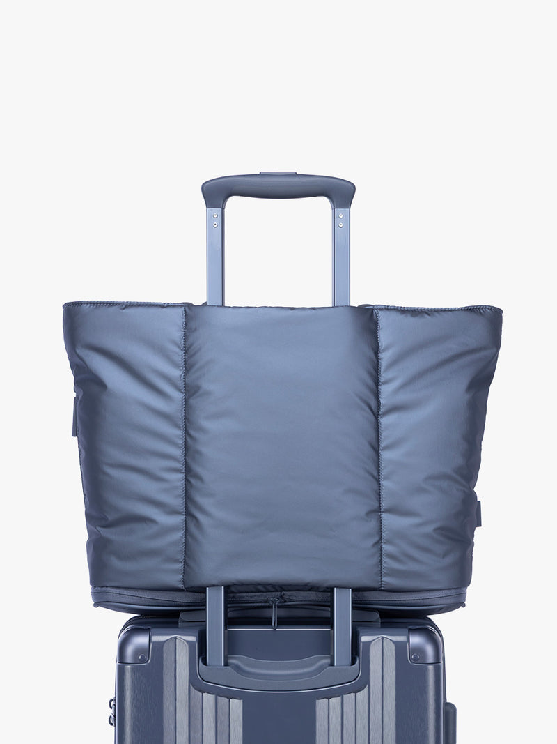 Luggage trolley sleeve of CALPAK Luka Expandable Tote in dark blue metallic material in Metallic Indigo