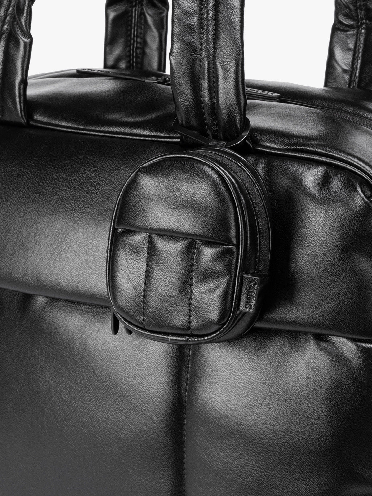 A close-up of Black CALPAK Luka Backpack Zip Bag Charm leather backpack keychain featuring a matching bag shown on a plain white background; AMB2201-BLACK-PU