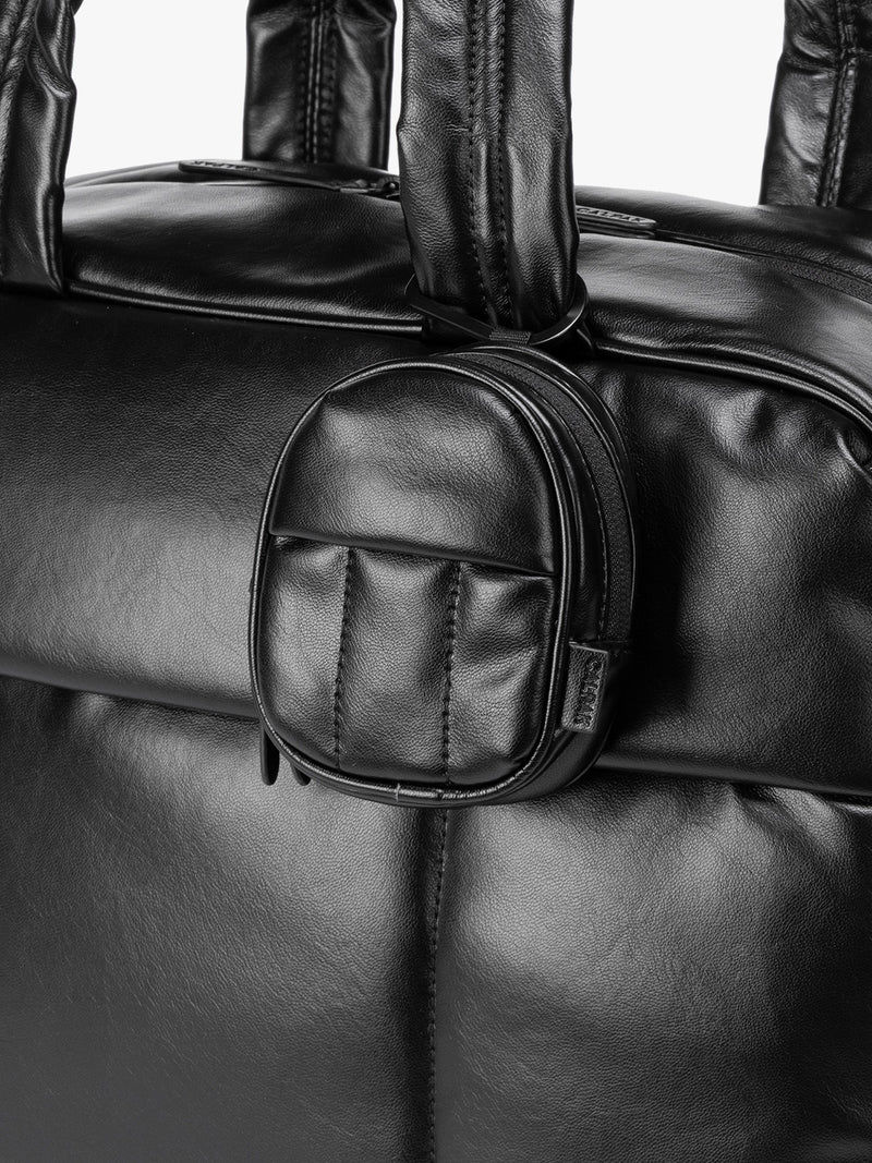 A close-up of Black CALPAK Luka Backpack Zip Bag Charm leather backpack keychain featuring a matching bag shown on a plain white background