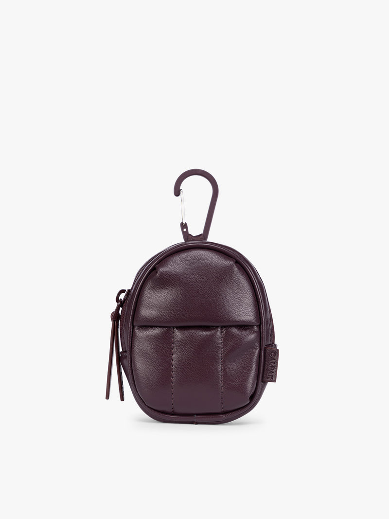 A small dark burgundy Dark Cherry CALPAK Luka Backpack Zip Bag Charm leather backpack keychain with a top carabiner and zipper pull, shown on a plain white background