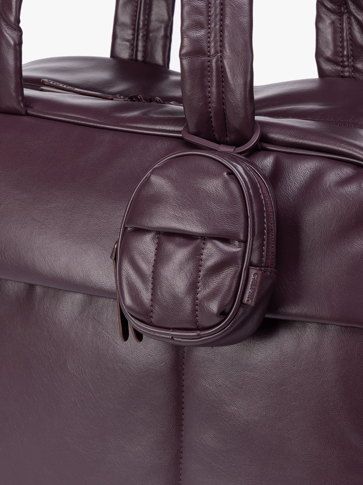 A close-up of dark burgundy Dark Cherry CALPAK Luka Backpack Zip Bag Charm leather backpack keychain featuring a matching bag shown on a plain white background; AMB2201-DARK-CHERRY-PU